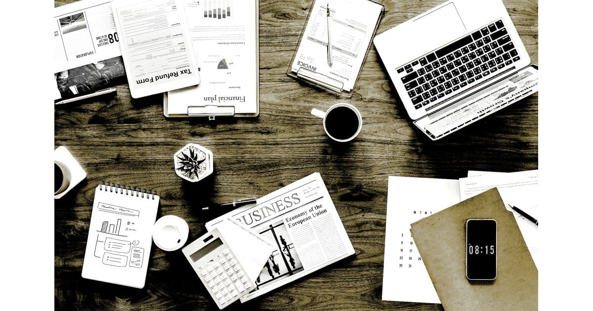 Effektives Marketing QUECCO Bünde: Moderner Business-Arbeitsplatz mit Laptop, Finanzberichten und Kaffee