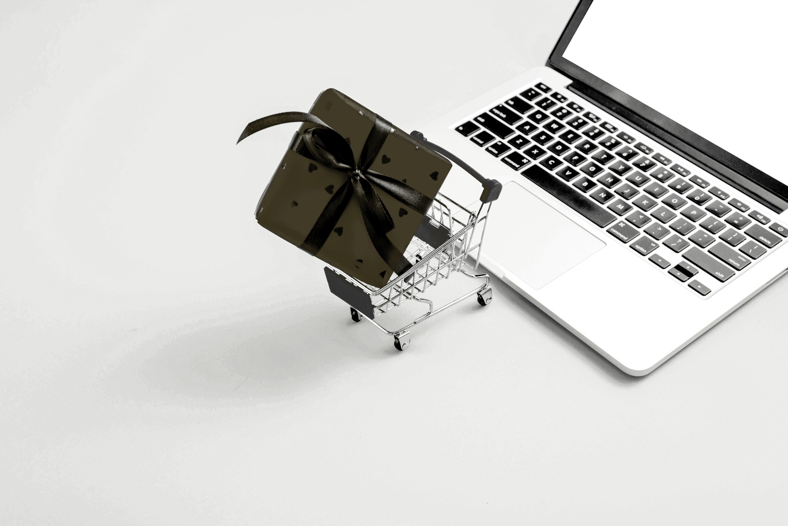 Social Media Marketing Onlineshops Hannover - Laptop mit Geschenkbox im Einkaufswagen zeigt Qualität