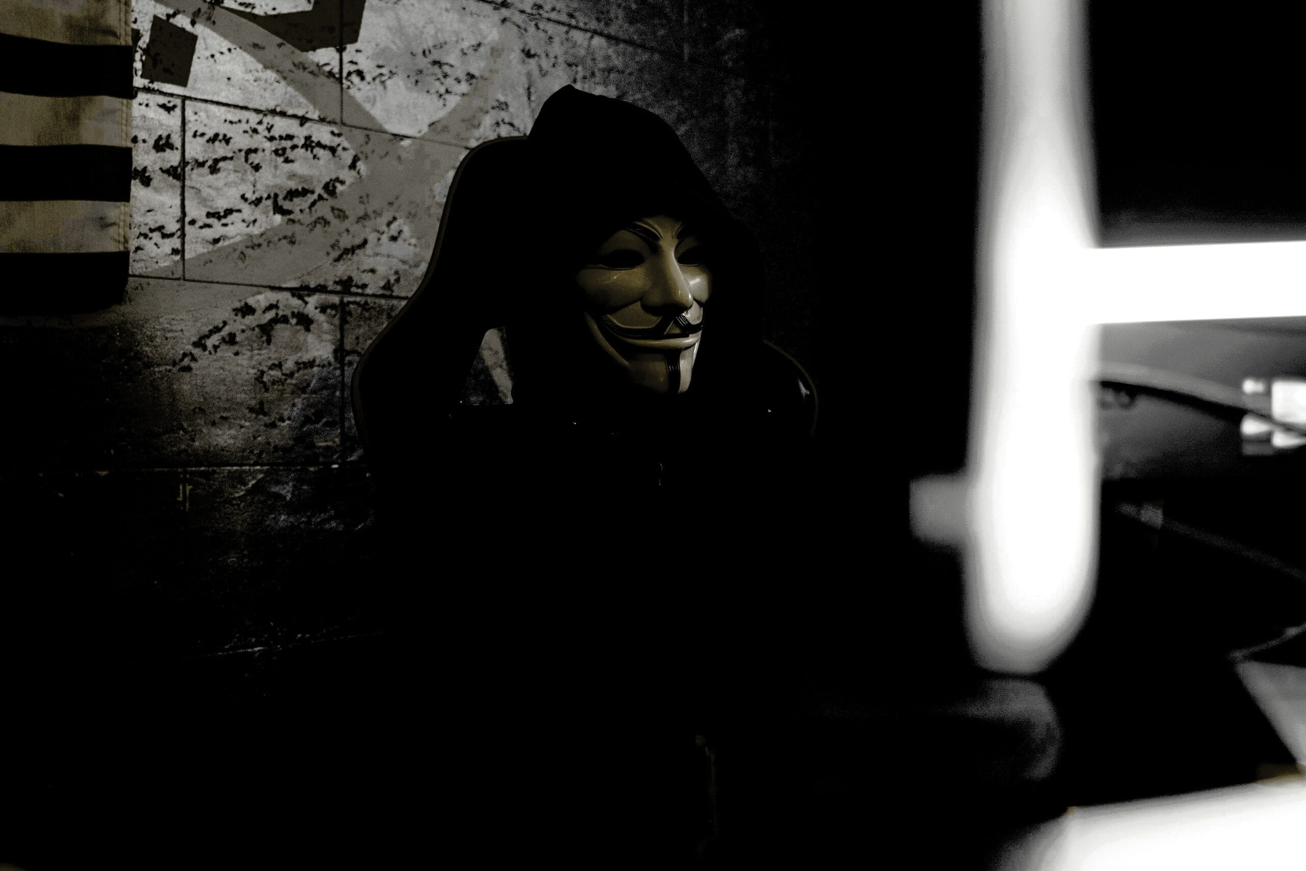 Thomas Scheffel warnt vor Jobsucher-Betrug: Vermummte Person mit Maske am Computer symbolisiert Täuschung